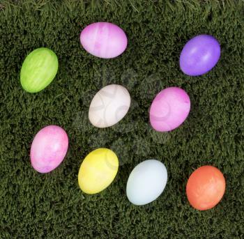 Colorful Easter egg decorations on green grass. Flat view.   
