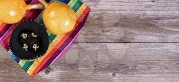 Flat view of maracas, sombrero and sombrero on rustic wooden boards for Cinco de Mayo concept. 