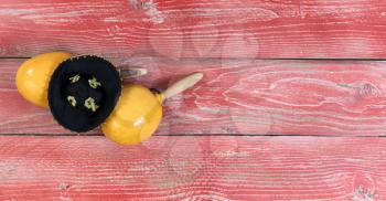 Flat view of yellow maracas and black sombrero on rustic red wooden boards for Cinco de Mayo concept. 