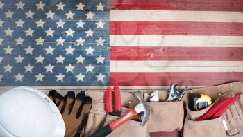 Labor Day background with USA rustic wooden flag and utility belt plus hard hat  