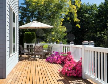 Summer home deck and blooming flower garden