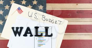 Wall construction subject with U.S. Budget concerns on rustic wooden USA flag for border national security