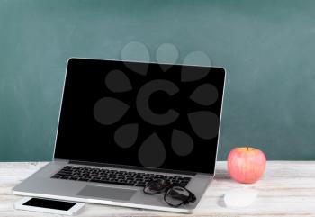 Back to school concept with modern wireless technologies and green chalkboard 