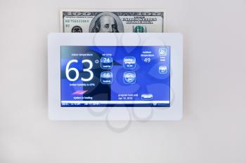 Modern digital thermostat technology to heat or cool home for energy savings concept