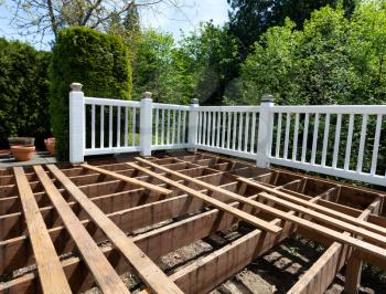 Outdoor wooden cedar deck being remodeled with floor boards being removed   