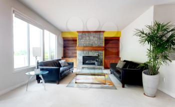 Modern living or family room including large glass table with leather couch and fireplace 