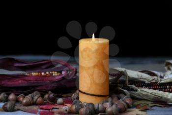 Burning candle for Thanksgiving or Halloween holiday with dark background setting