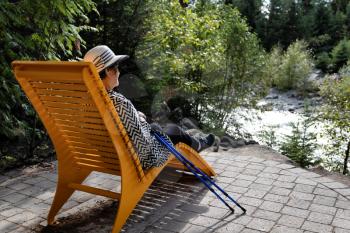 Portrait of senior woman relaxing outdoors in chair after hiking