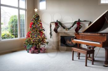 Brightly illuminated Christmas tree with glowing fireplace in home during day time    