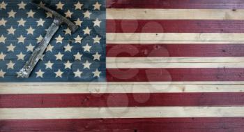 Vintage construction hammer on rustic wooden US flag background with copy space