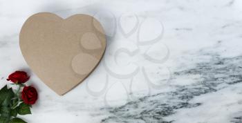 Happy Valentines Day with lovely red rose flowers plus large heart shaped giftbox on natural marble stone background 