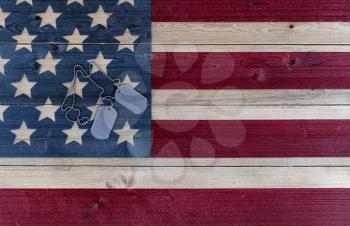 Military ID tags for Memorial, 4th of July and Veterans Day holiday on rustic US wooden flag 
