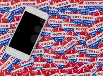Smartphone position on top of I voted today stickers background with United States national colors or red, white and blue 