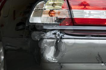 Damaged bumper and taillight on automobile from collision 