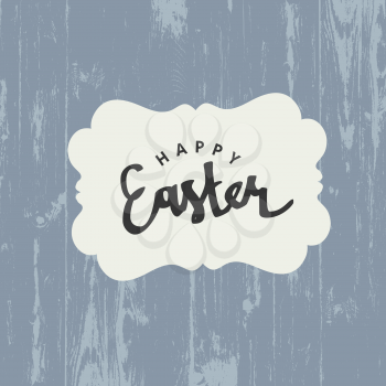 Easter greeting card with Happy Easter text on white label on wooden board