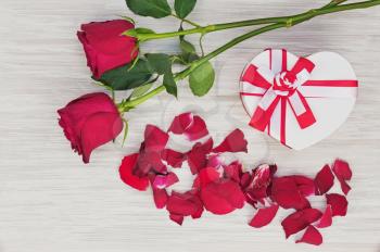 Valentine`s Day gift and roses on wooden background. Closeup.