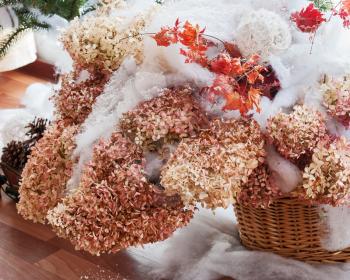 Bouquet from hydrangea, autumn leaves and snow in basket.