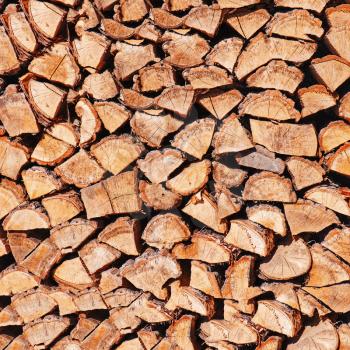 Dry chopped firewood logs in pile. Nature background. 