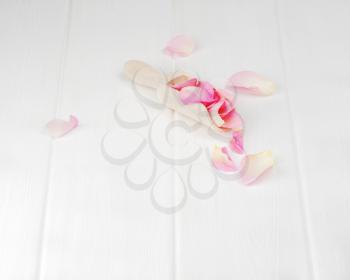 Rose petals on white wooden plates. Closeup.