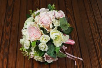 Beautiful wedding bouquet from white and pink roses on wooden background.