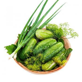 Cucumbers and vegetables and dill leaves still life in wooden bowl isolated on white background. Closeup