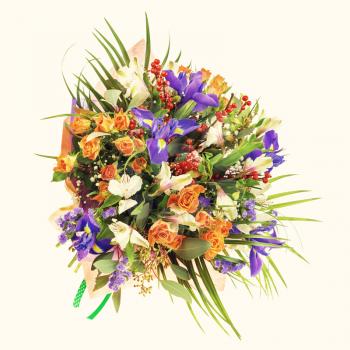 Delicate beautiful bouquet of nerine, iris, alstroemeria, roses and other flowers in orange packaging with green tape. Photo with retro filter effect. 