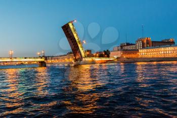 Night view of illuminated drawbridge (Foundry Bridge) on night river Neva water, one of the most familiar images of the Northern capital of Russia, Saint Petersburg.