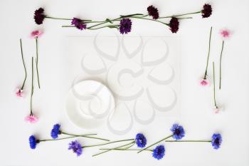 Plate with decoration of flowers on white background. Overhead view. Flat lay.