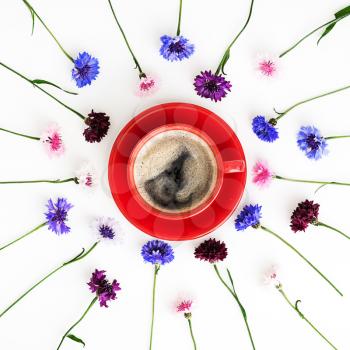 Cup  of coffee with pattern from petals of wildflowers on white background. Overhead view. Flat lay.