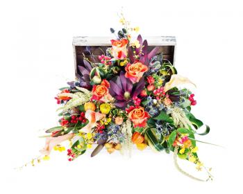 Colorful floral arrangement of roses, lilies, freesia and irises in wooden chest isolated on white background.