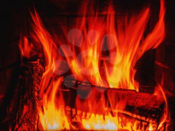 Fireplace with burning woods and fire. Closeup.