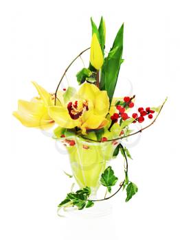Bouquet from orchids, tulips and ivy arrangement centerpiece in glass vase isolated on white background.
