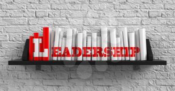 Royalty Free Photo of Books on a Shelf Against a Brick Wall With the Word Leadership