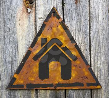 Royalty Free Photo of a House on a Rusty Sign Against a Wooden Wall