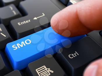 SMO - Social Media Optimization - Written on Blue Keyboard Key. Male Hand Presses Button on Black PC Keyboard. Closeup View. Blurred Background.