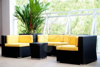Hotel deck interior furniture with black sofa and chairs and yellow pillows