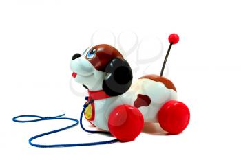 Old toy plastic dog with wheels isolated on white