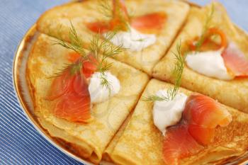 Roasted thin pancakes with smoked salmon and sauce