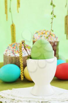 Green egg in a white ceramic base