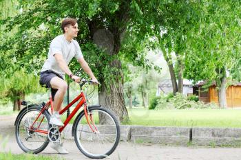 Young handsome bicyclist in a summer park