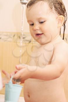 Little girl in the bathroom playing with water