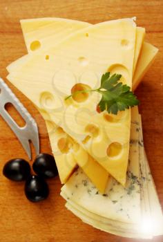 a large piece of  Swiss cheese and black olives
