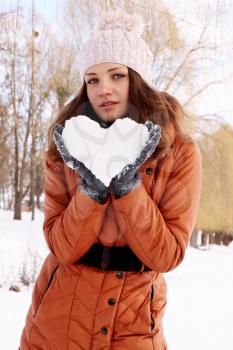 woman holds a heart of ice in the hands of