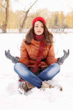 young woman in a lotus position on the snow