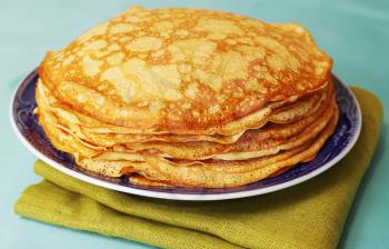 pile of ruddy pancakes on blue plate
