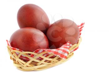 Three burgundy eggs in the basket of birch bark