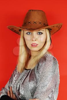 woman in a cowboy hat on a red background