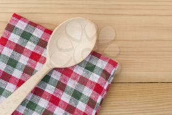 Wooden spoon and a checkered napkin on the table.