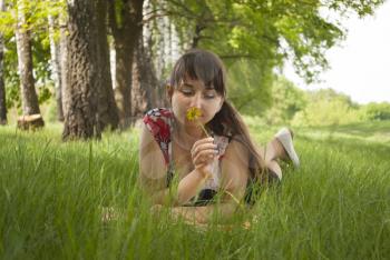 Girl lying on the grass with a flower in her hand