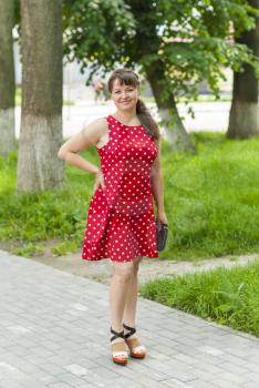 Young beautiful girl in a dress for a walk in the park.